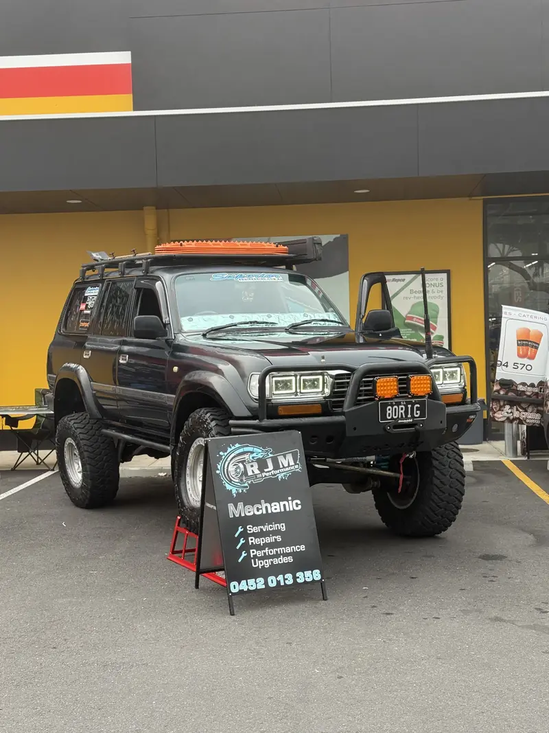 Lifted 80 Series Toyota LandCruiser beside the RJM Performance A-frame sign