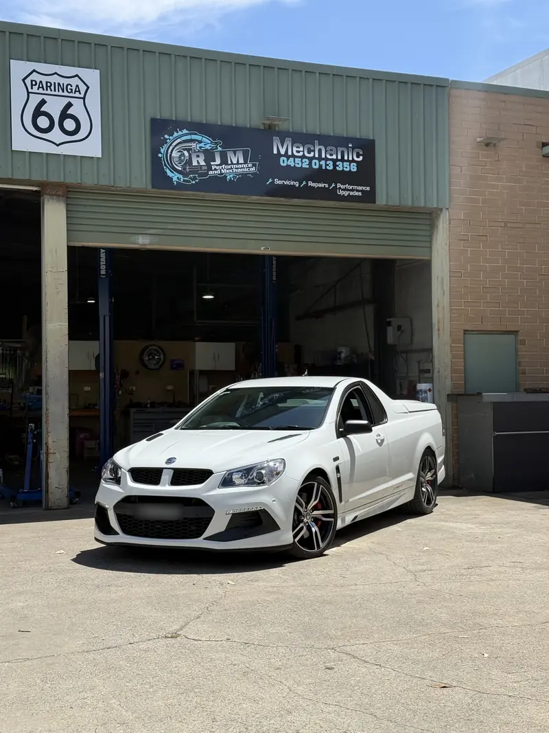 White V8 ute parked out front of the RJM Performance workshop under the Mechanic sign